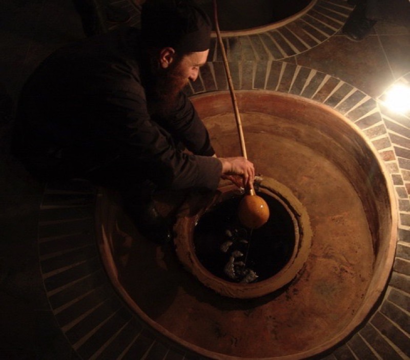 A winemaker checks on his product, which ages to perfection in an underground qvevri. Photo credit: John Wurdeman