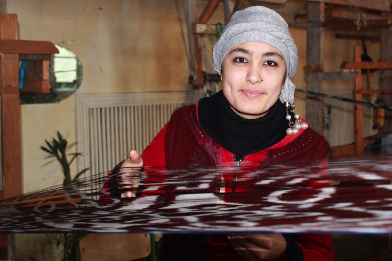 A weaver in Fergana demonstrates the time-consuming process of making silk fabrics by hand. Photo credit: Marina Karptsova