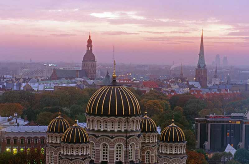 The sun sets over the rooftops of Riga, Latvia. Photo credit: Peter Guttman