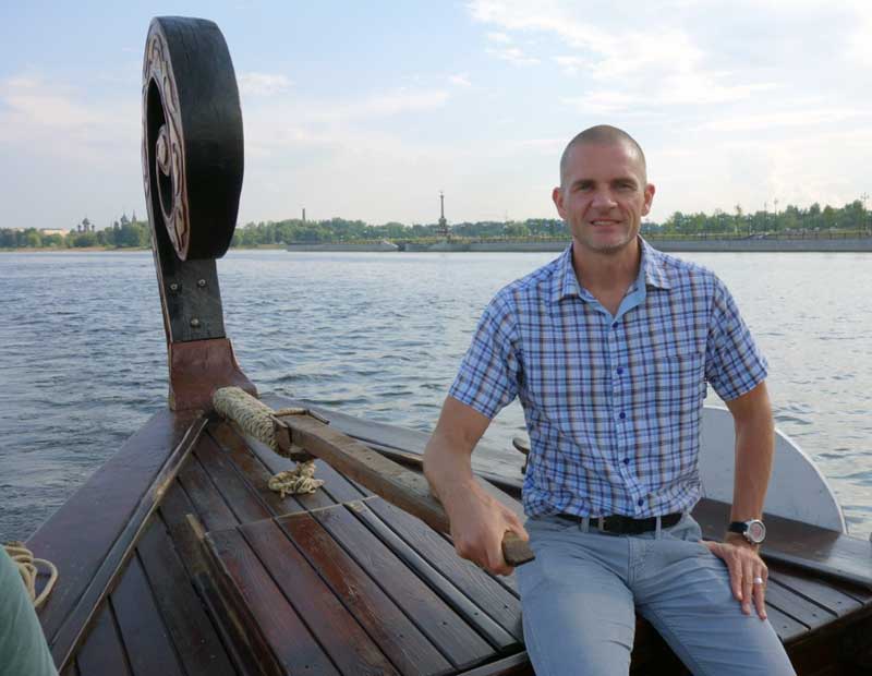 John steers the boat on the Volga River