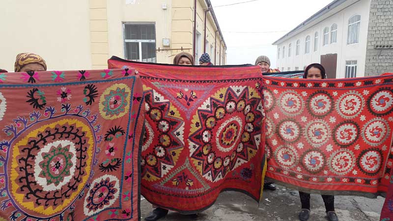 Suzani vendors display their handiwork at a local market. Photo credit: Anya von Bremzen