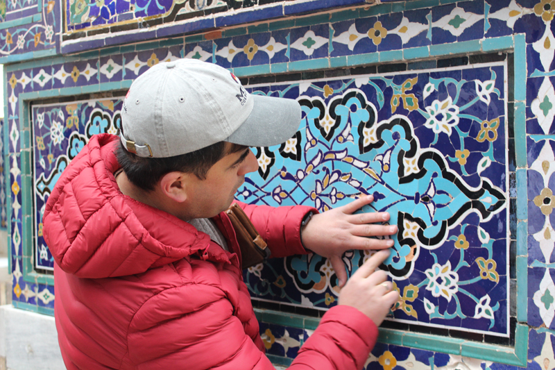 MIR Tour Manager Abdu Samadov explains the significance of the patterns in Silk Road tile work. Photo credit: Tia Low