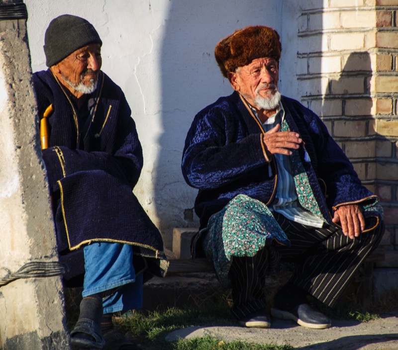 Two friends, wearing the traditional men’s chapan enjoy a quiet moment in Bukhara. Photo credit: Lindsay Fincher